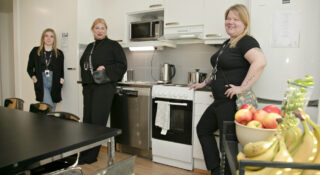 Kolme naista seisoo keittiössä