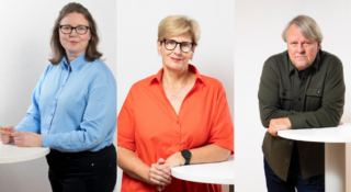 Kaksi naista ja yksi mies seisovat vierekkäin