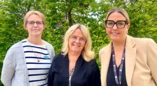 Kolme naista vierekkäin puistossa