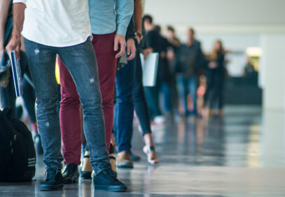 Ihmisiä jonottamassa toimiston käytävällä