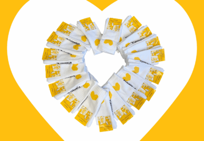 Talentia-tennissukkia järjestettynä sydämenmuotoon valkoisella taustalla, jossa keltainen sydämenmuotoinen kehys.