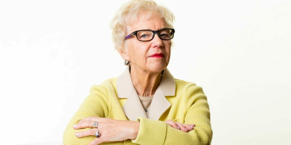 Silmälasipäinen nainen kädet ristissä