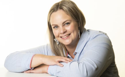 Vaaleahiuksinen nainen sinisessä puserossa