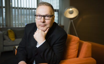 Mies istuu nojatuolissa