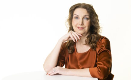 Pitkähiuksinen nainen istuu