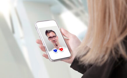 Nainen pitää kädessään kännykkää missä vanhemman miehen kuva