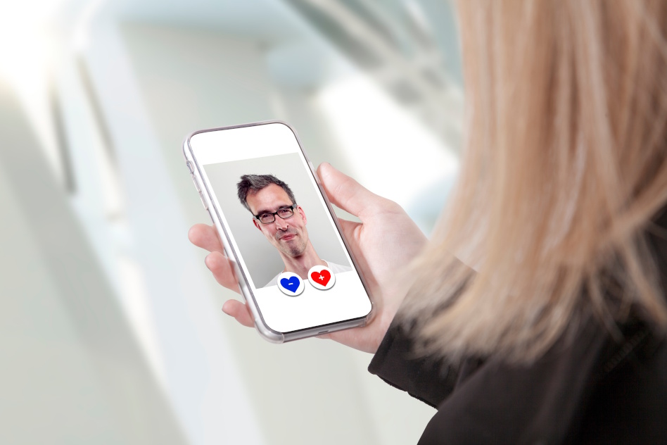 Nainen pitää kädessään kännykkää missä vanhemman miehen kuva