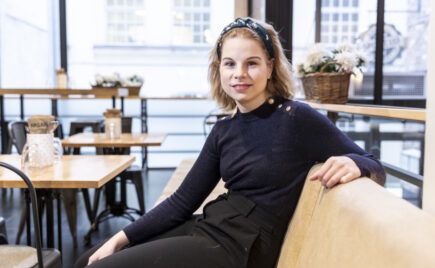 Vaaleatukkainen nainen istuu sohvalla