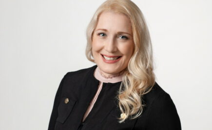 Vaaleahiuksinen nainen mustassa puserossa