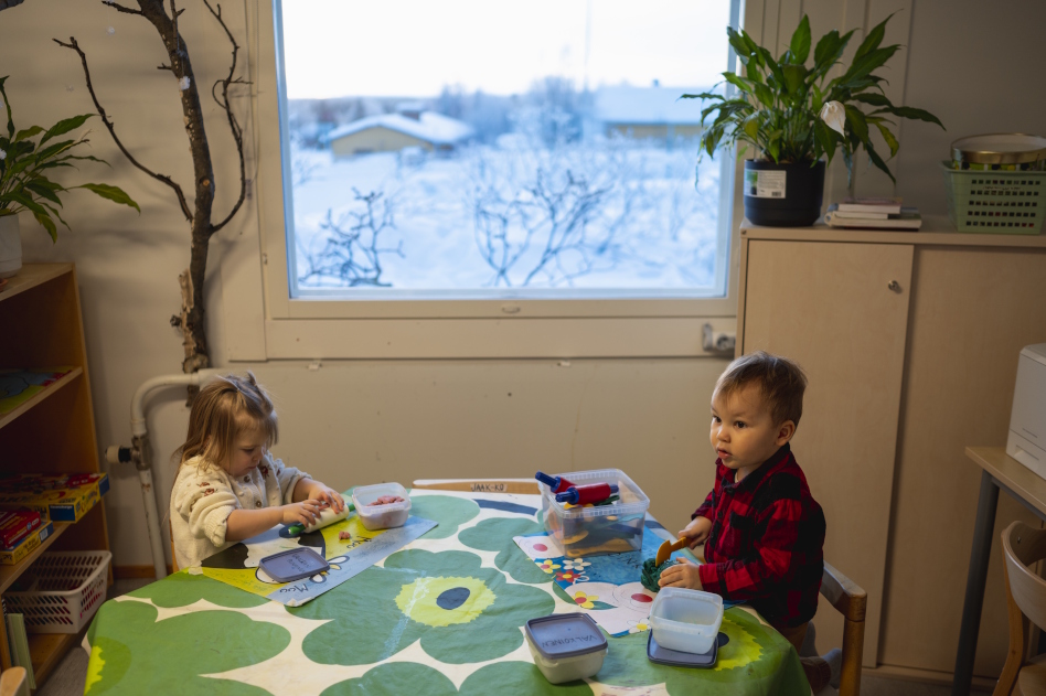 Kaksi lasta leikkii pöydän ääressä
