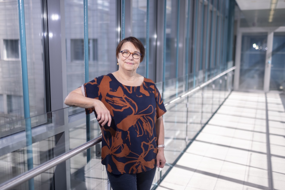 Silmälasipäinen nainen lasiseinän edessä