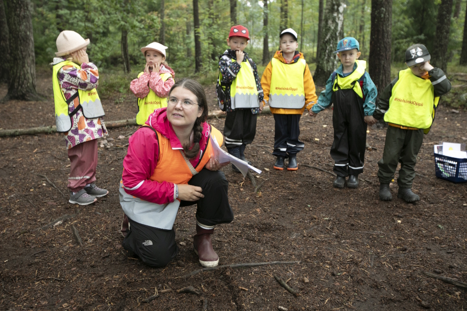 Päiväkotilapsia aikuisen kanssa metsässä