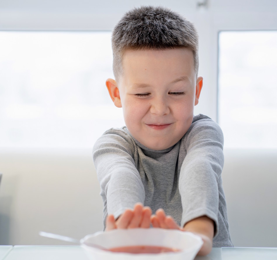 Pikkupoika työntää ruokalautasta poispäin itsestään