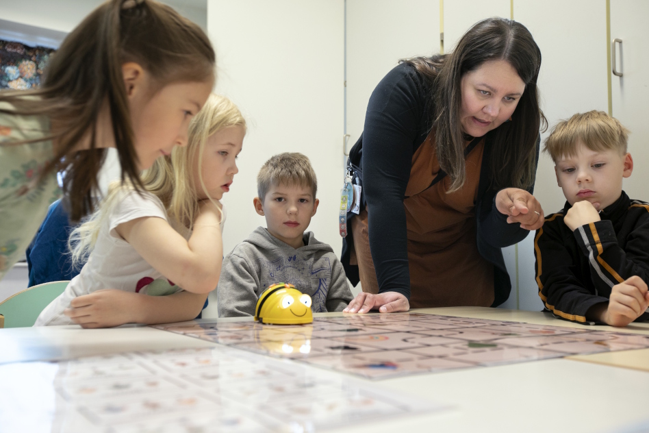 Lapset leikkivät pienellä robotilla