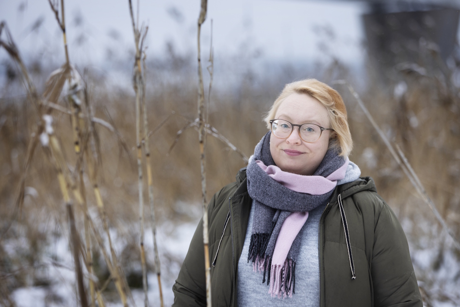 Vaaleahiuksinen, silmälasipäinen nainen ulkona