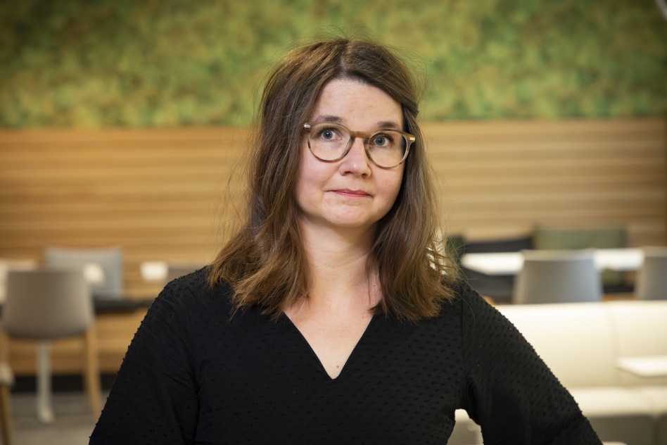 Tummahiuksinen nainen silmälasit päässä