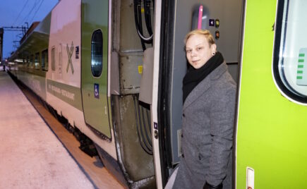 Mies seisoo junan oven edessä.