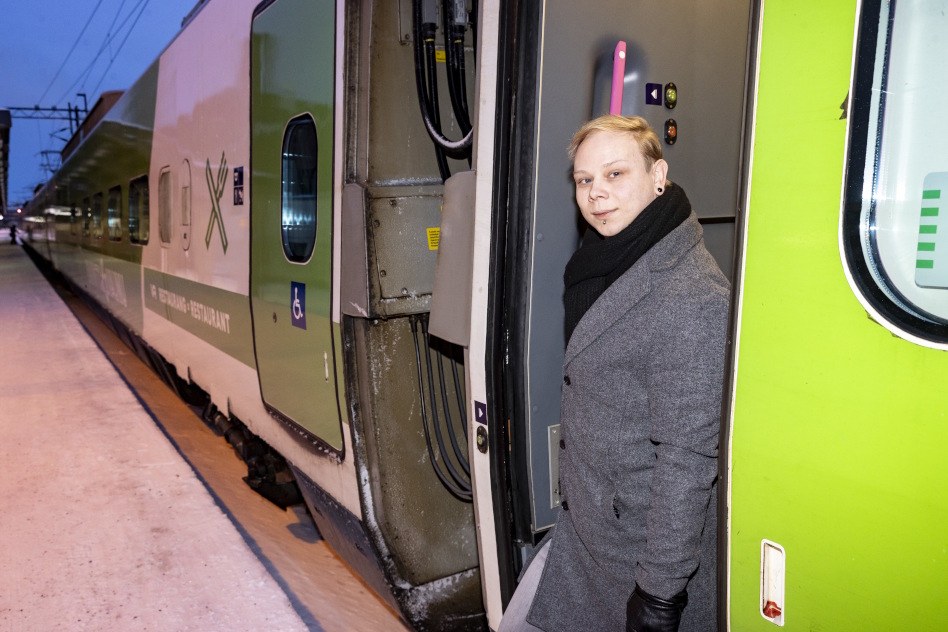 Mies seisoo junan oven edessä.