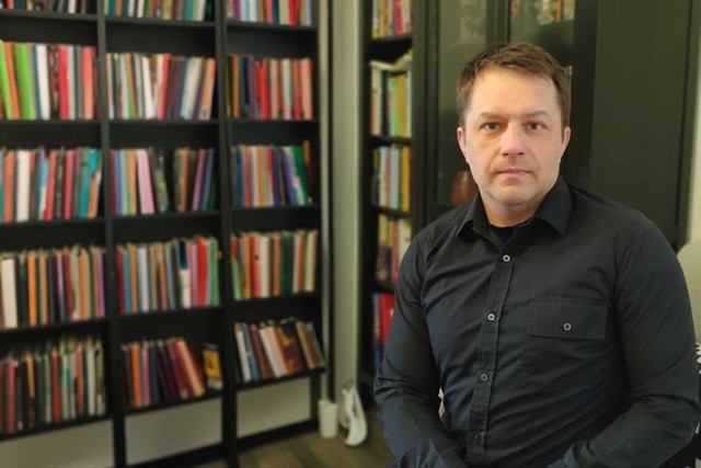 MIes kirjahyllyn edessä