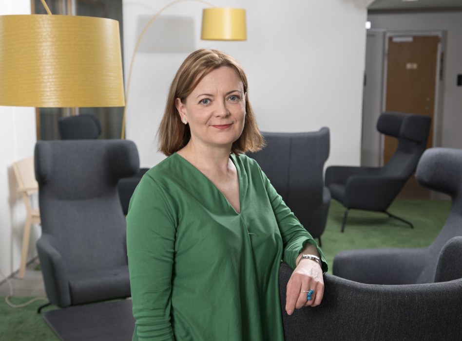 Pitkähiuksen nainen vihreässä puserossa.