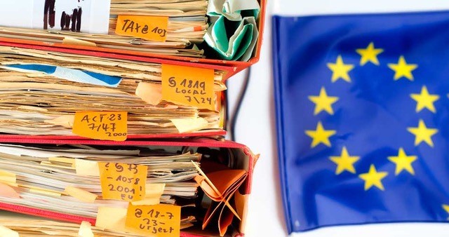 EU:n lippu ja sen vieressä iso mappipino