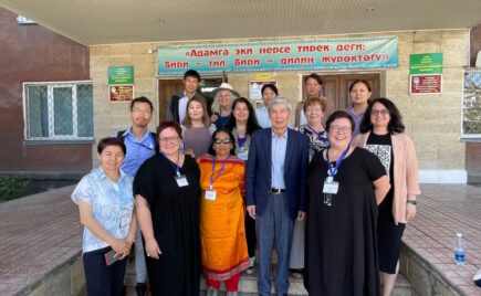 joukko ihmisiä seisoo kirgisialaisen rakennuksen edessä