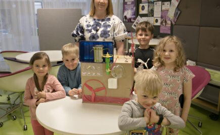 Päiväkotilapsia opettajan kanssa esittelemässä tekemäänsä ruokarobottia