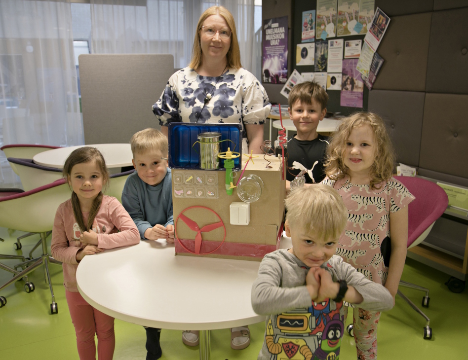 Päiväkotilapsia opettajan kanssa esittelemässä tekemäänsä ruokarobottia