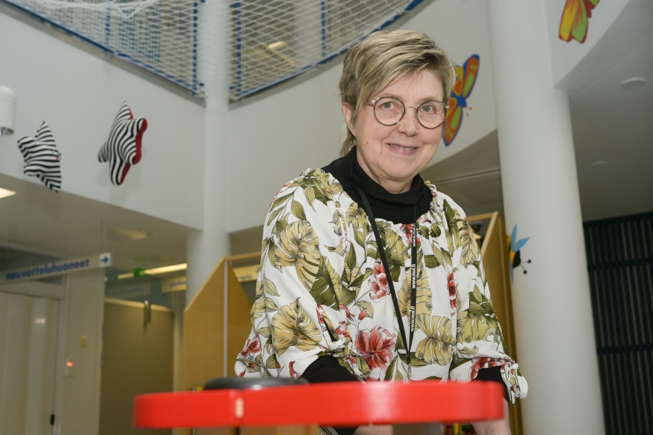 Silmälasipäinen naineen istuu pöydän edessä