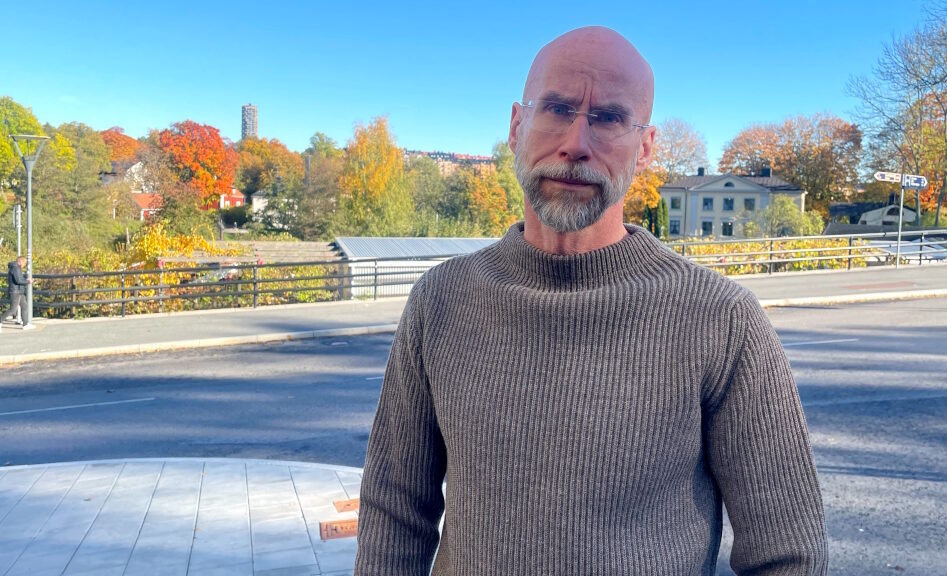 Kaljupäinen mies harmaassa villapaidassa