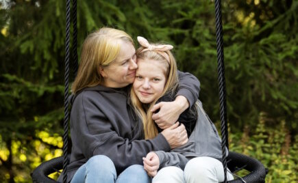 Vanhempi nainen halaa nuorta tyttöä.