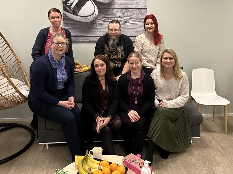 Ryhmä ihmisiä istuu sohvalla