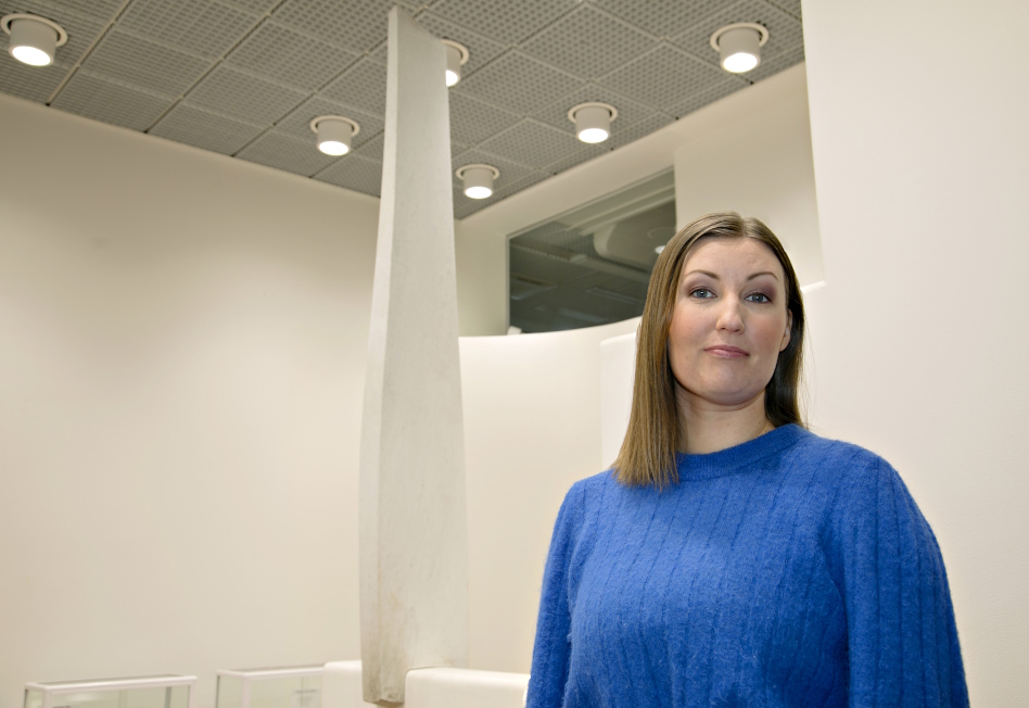 Pitkähiuksinen nainen kirkkaan sinisessä puserossa.