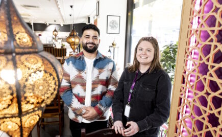 Nauravat mies ja nainen seisovat ravintolan eteisessä