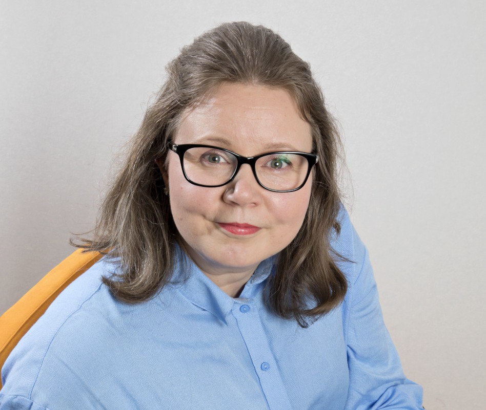 Silmälasipäinen nainen sinisess puserossa