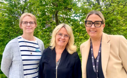 Kolme naista vierekkäin puistossa