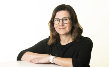 Silmälasipäinen nainen pöydän ääressä