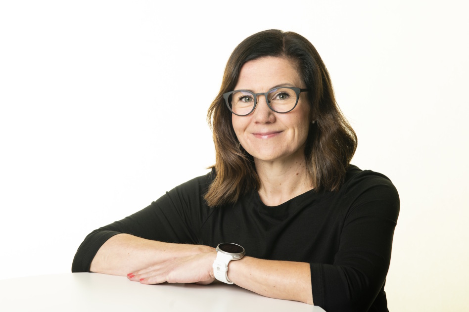 Silmälasipäinen nainen pöydän ääressä