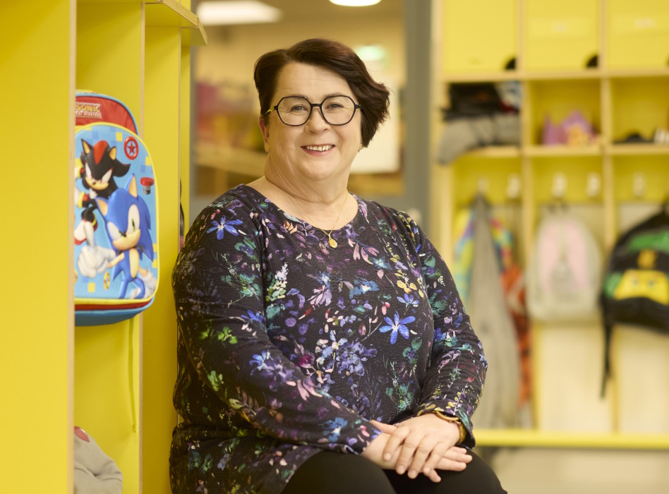 Nainen istuu päiväkodin eteisessä