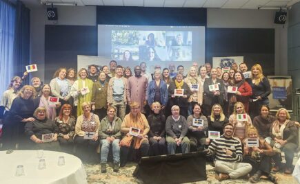 Iso joukko ihmisiä istuu ja seisoo ryhmäkuvassa.