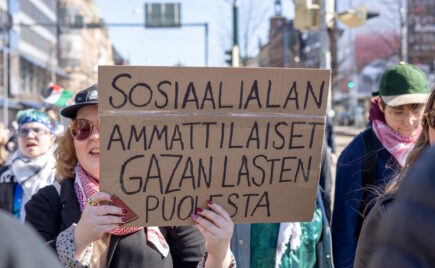 Kaksi naista mielenosoituksessa kyltin kanssa