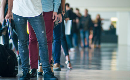 Ihmisiä jonottamassa toimiston käytävällä