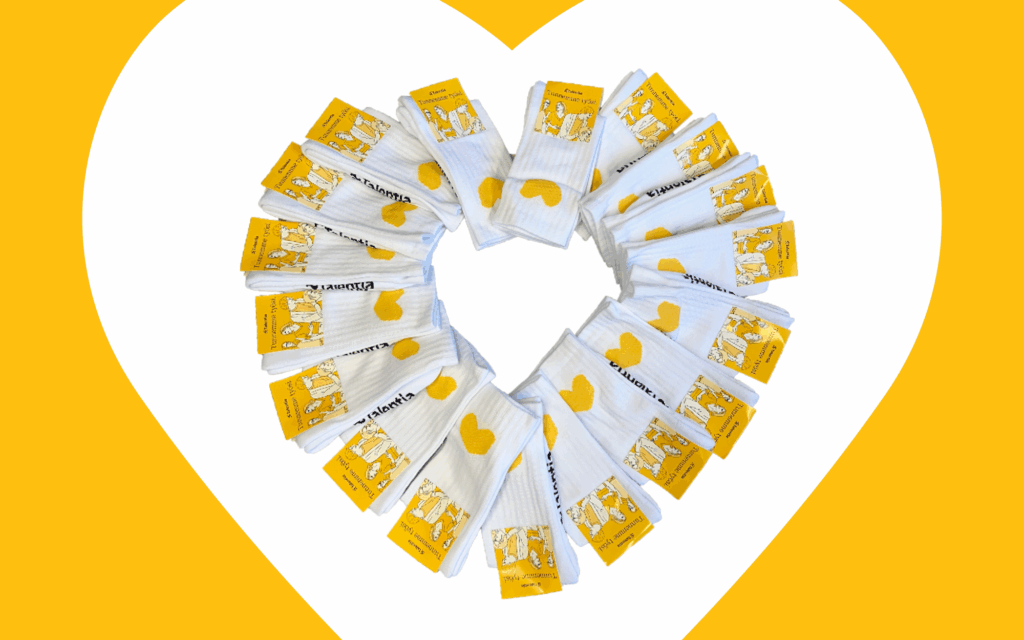 Talentia-tennissukkia järjestettynä sydämenmuotoon valkoisella taustalla, jossa keltainen sydämenmuotoinen kehys.