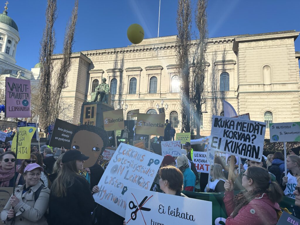 Joukko mielenosoittajia kyltit kädessä