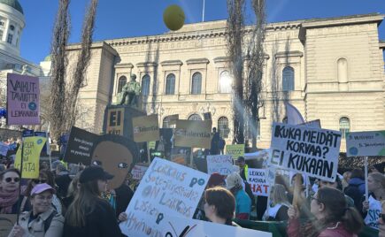 Joukko mielenosoittajia kyltit kädessä