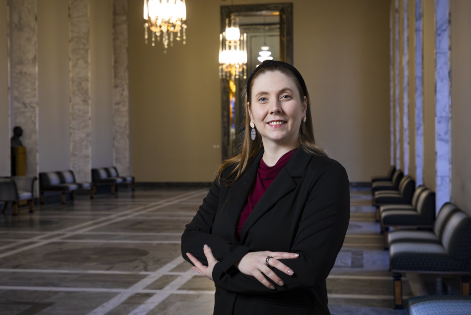 Pitkähiuksinen nainen seisoo eduskuntatalon käytävällä.