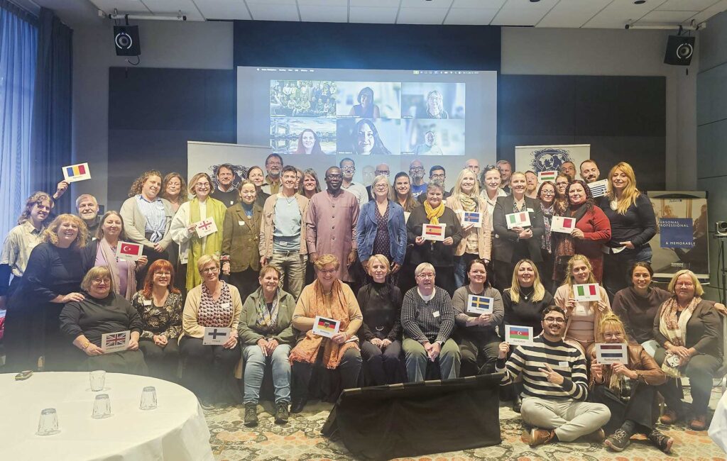 Iso joukko ihmisiä istuu ja seisoo ryhmäkuvassa.