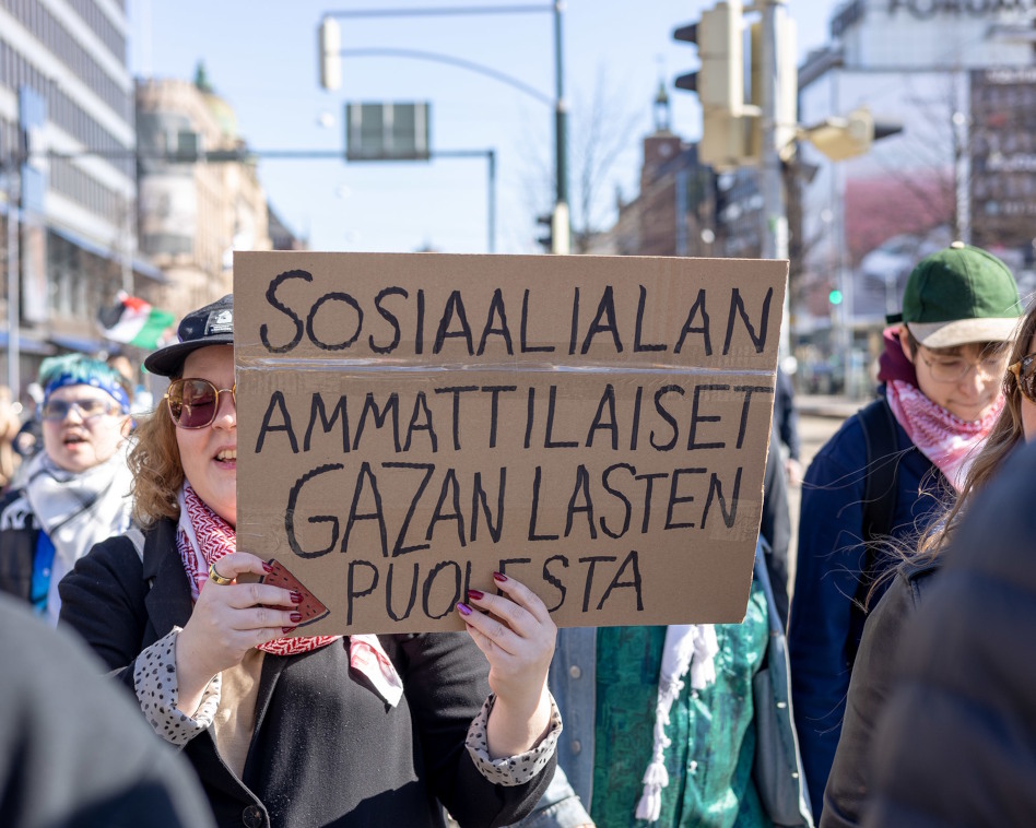 Kaksi naista mielenosoituksessa kyltin kanssa